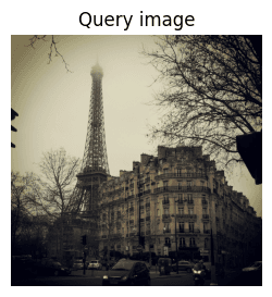 Grayscale photo of the Eiffel Tower surrounded by Haussmann-style buildings on a foggy day, used as the query image for image-to-image similarity search.